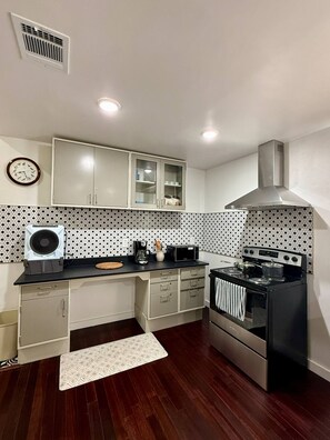 A kitchen with a stove, microwave, and cabinets.