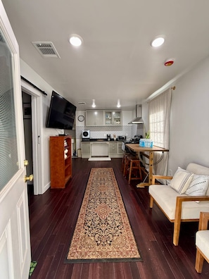 A modern living room with a sofa, a coffee table, and a TV mounted on the wall.