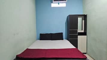 Un dormitorio con cama, armario y aire acondicionado en la pared.
