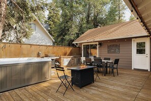 An outdoor patio with a hot tub, grill, and dining area. - Deer & Pine - Hot tub, Dogs ok, Large Patio (Big Bear Lake)