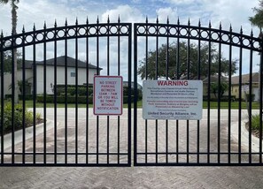 A gated entrance with a no street parking sign and a warning sign about security surveillance. - The Jedi Lounge/Pool/Spa/Arcade & Starry Night (Davenport)