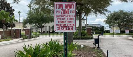 A tow-away zone sign with a contact number for the Center State Automotive.