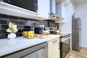 A modern kitchen with a dishwasher, microwave, stove, and refrigerator. - Welcome to Sapphire Inn which is 13  minutes from YYC Calgary Airport (Calgary)