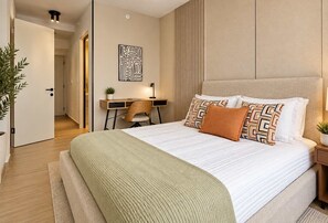 A modern hotel room with a large bed, a desk, and a chair. - PAN - TH - 2B (17E) (Panamá)