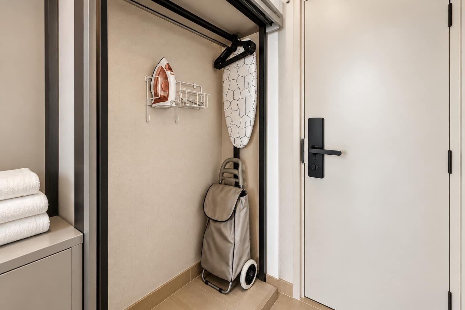 A bathroom with a towel rack, an iron, and a wheelchair.