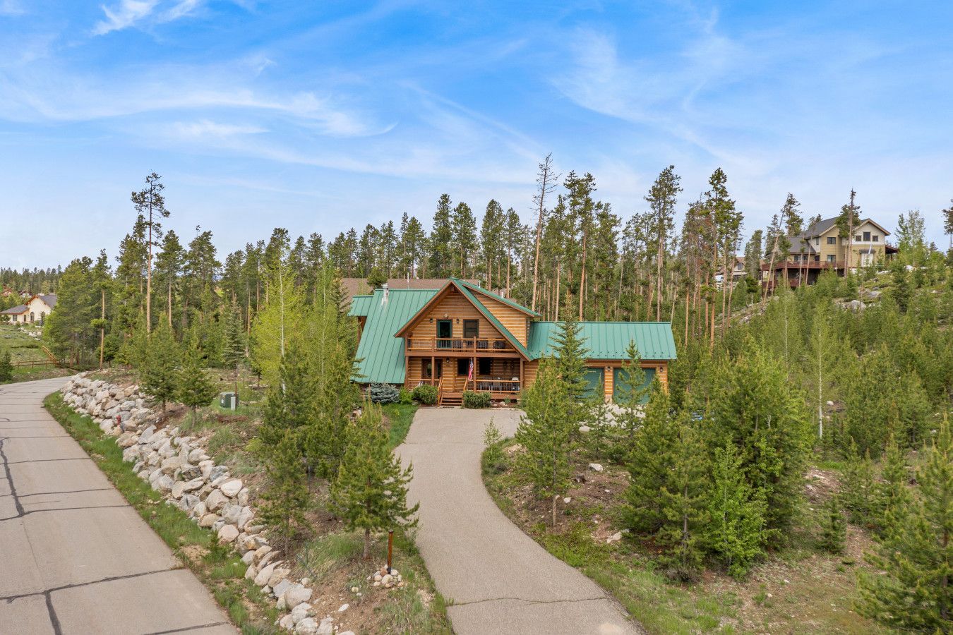 Een lodge met een groen dak, omringd door dicht bos.