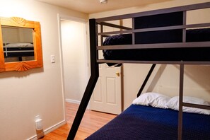 Een stapelbed met een blauwe matras en een houten hoofdeinde.
