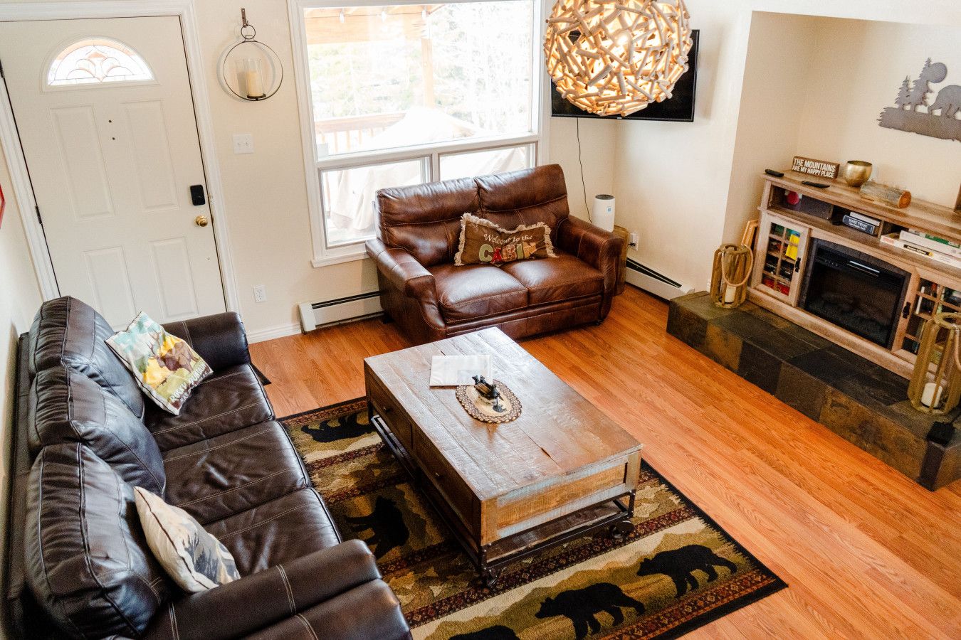 A living room with a brown leather sofa, a wooden coffee table, and a fireplace.