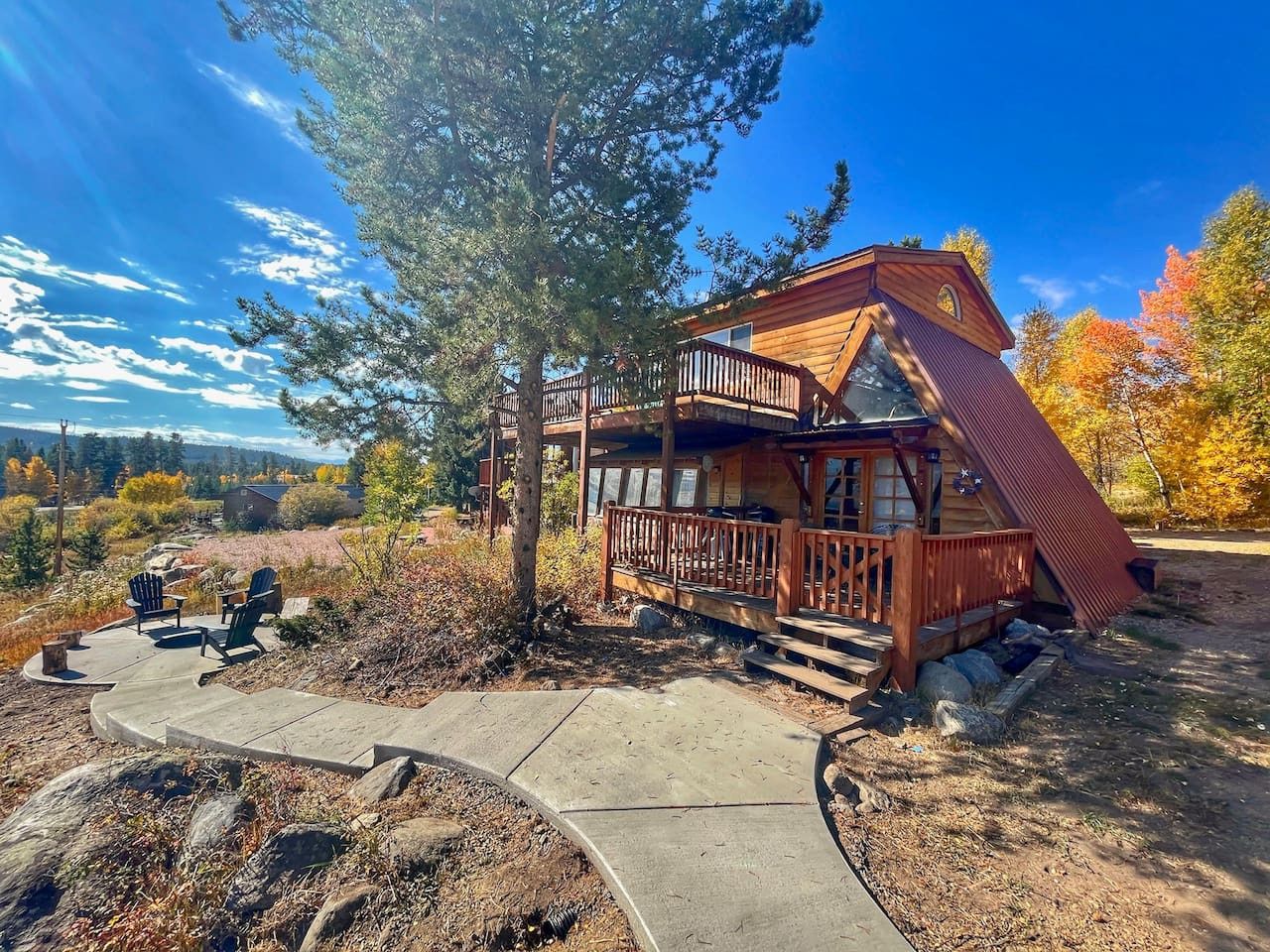 Une cabane dotée d’une terrasse en bois, d’un espace salon extérieur et offrant une vue panoramique.
