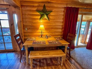 A wooden interior with a star decoration, a table with placemats, and a bench.