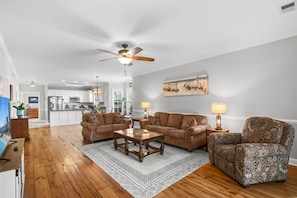 A spacious living room with a large brown sofa set, a patterned armchair, and a wooden coffee table. - Magnolia Pointe Golf & Beach Retreat Myrtle Beach (Myrtle Beach)