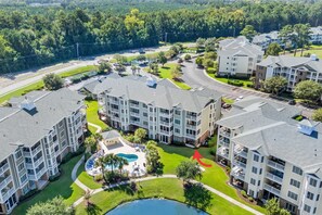 A multi-story residential building with a central courtyard featuring a swimming pool and lounge area. - Magnolia Pointe Golf & Beach Retreat Myrtle Beach (Myrtle Beach)