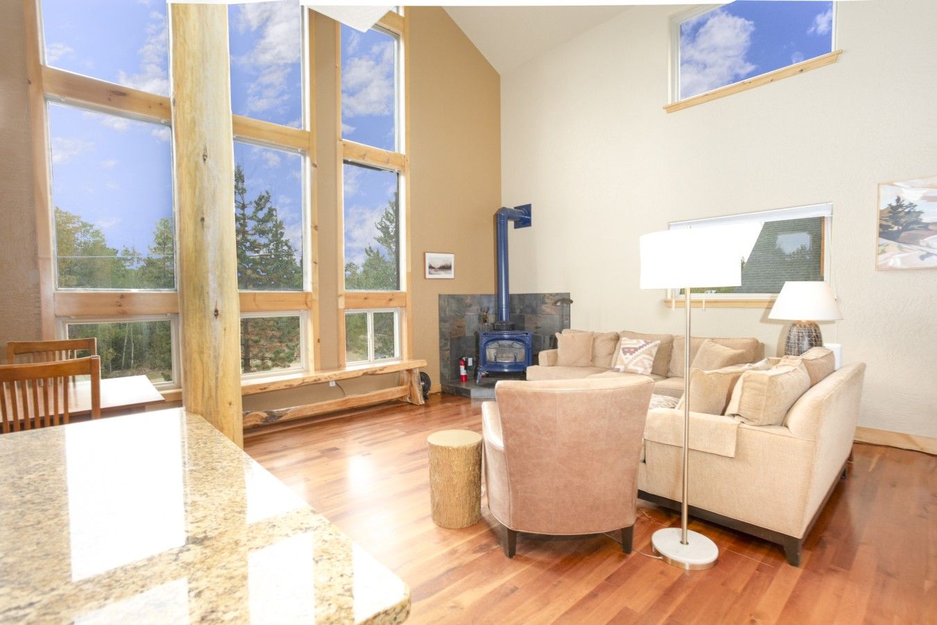 A spacious living room with large windows, a fireplace, and a cozy seating area.