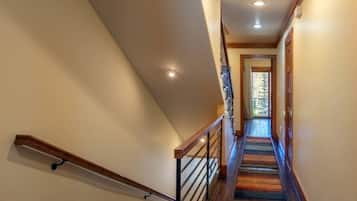 Una escalera con barandas de madera y un rellano alfombrado.