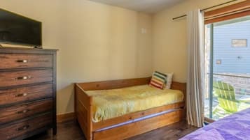 Un dormitorio con una cama de madera, un aparador y un televisor.