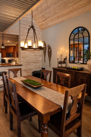 A dining area with a wooden table, chairs, and a chandelier. - Downtown luxury retreat, Lake and MTN views, Yoga (Grand Lake)