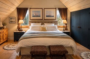 A bedroom with a large bed, two bedside tables, a dresser, and a wardrobe. There are two windows with curtains, and the room has a sloped ceiling. - Downtown luxury retreat, Lake and MTN views, Yoga (Grand Lake)