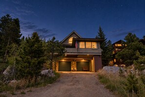 A two-story house with a stone facade, an American flag, and a driveway leading to the entrance. - Downtown luxury retreat, Lake and MTN views, Yoga (Grand Lake)