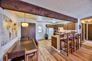 Une cuisine dotée de meubles en bois, d’un îlot central et d’un coin repas avec une table et des chaises.