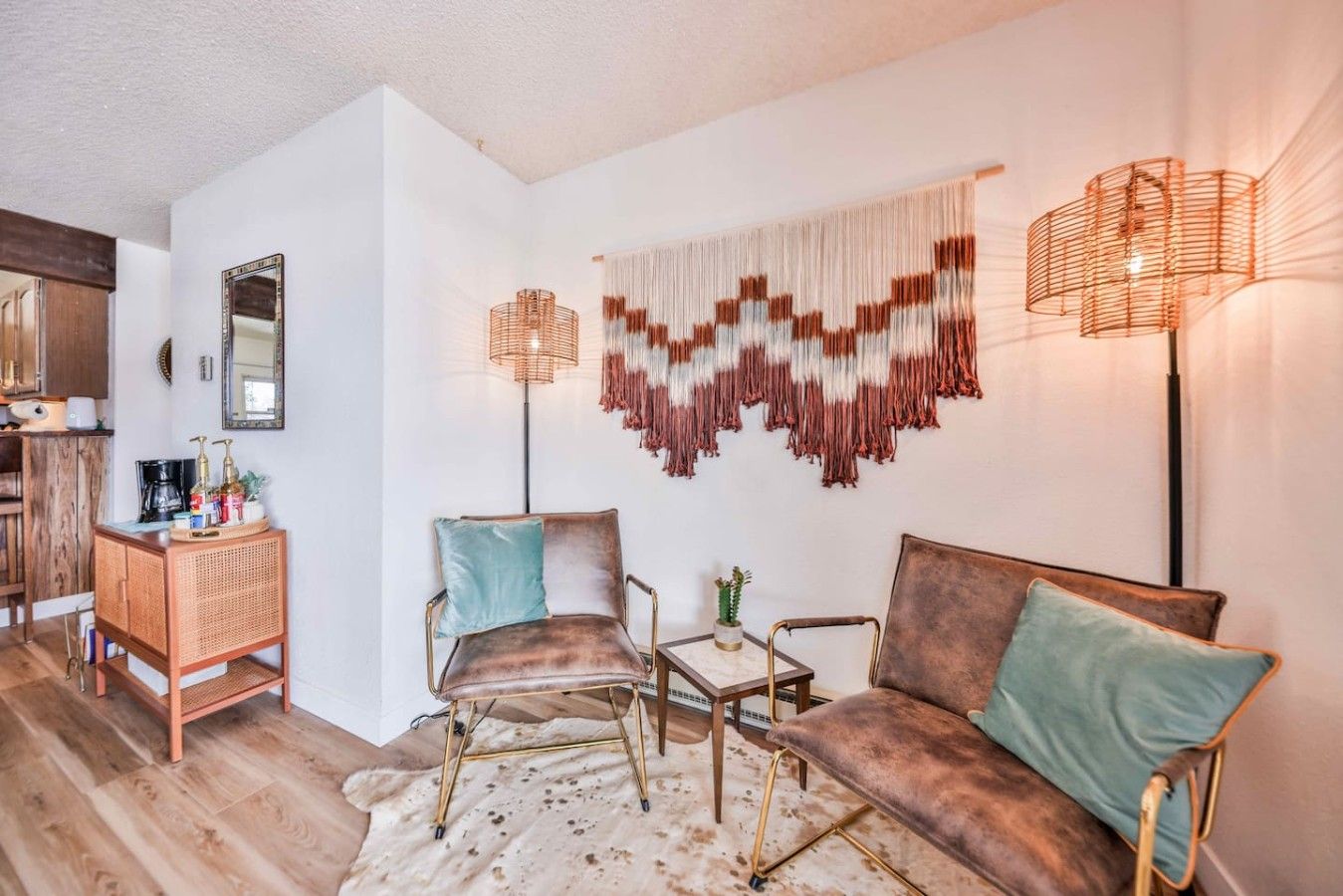 A cozy living area with a sofa, two armchairs, a coffee table, and a wall-mounted lamp.