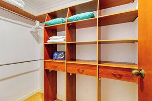 Ein Schrank mit Holzböden, einer Kleiderstange und einer Aufbewahrungsbox.