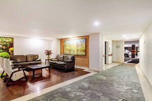 A modern living room with leather sofas, a coffee table, and a large painting on the wall. - Charming 2-bedroom Apartment in Medellín's Golden Mile (Medellín)