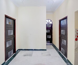 A hallway with two doors, each with a number plate, leading to a staircase.