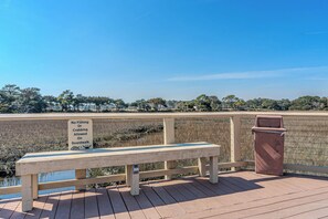 A wooden bench on a boardwalk with a 'No Fishing or Crabbing Allowed' sign, overlooking a body of water and trees. - 2BR Resort Escape - Pools and Bars (Hilton Head Island)