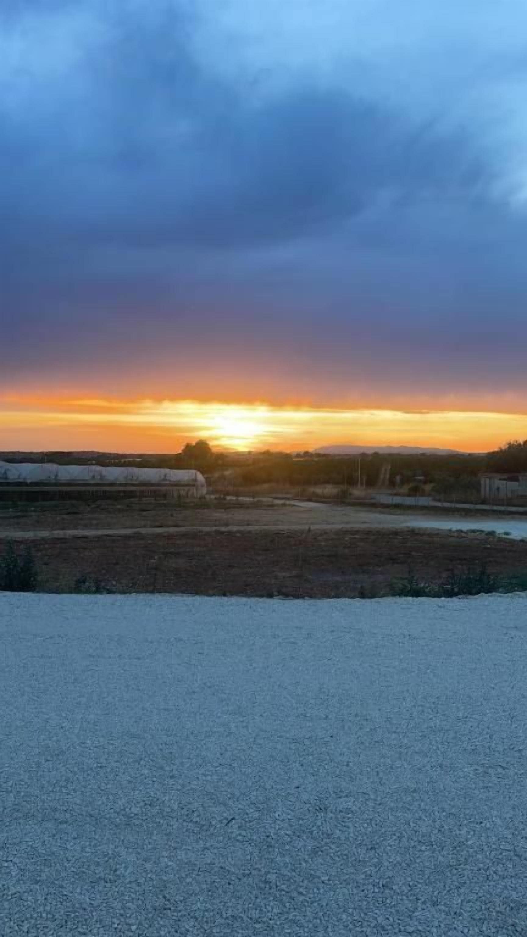 Un paisaje llano con un atardecer.