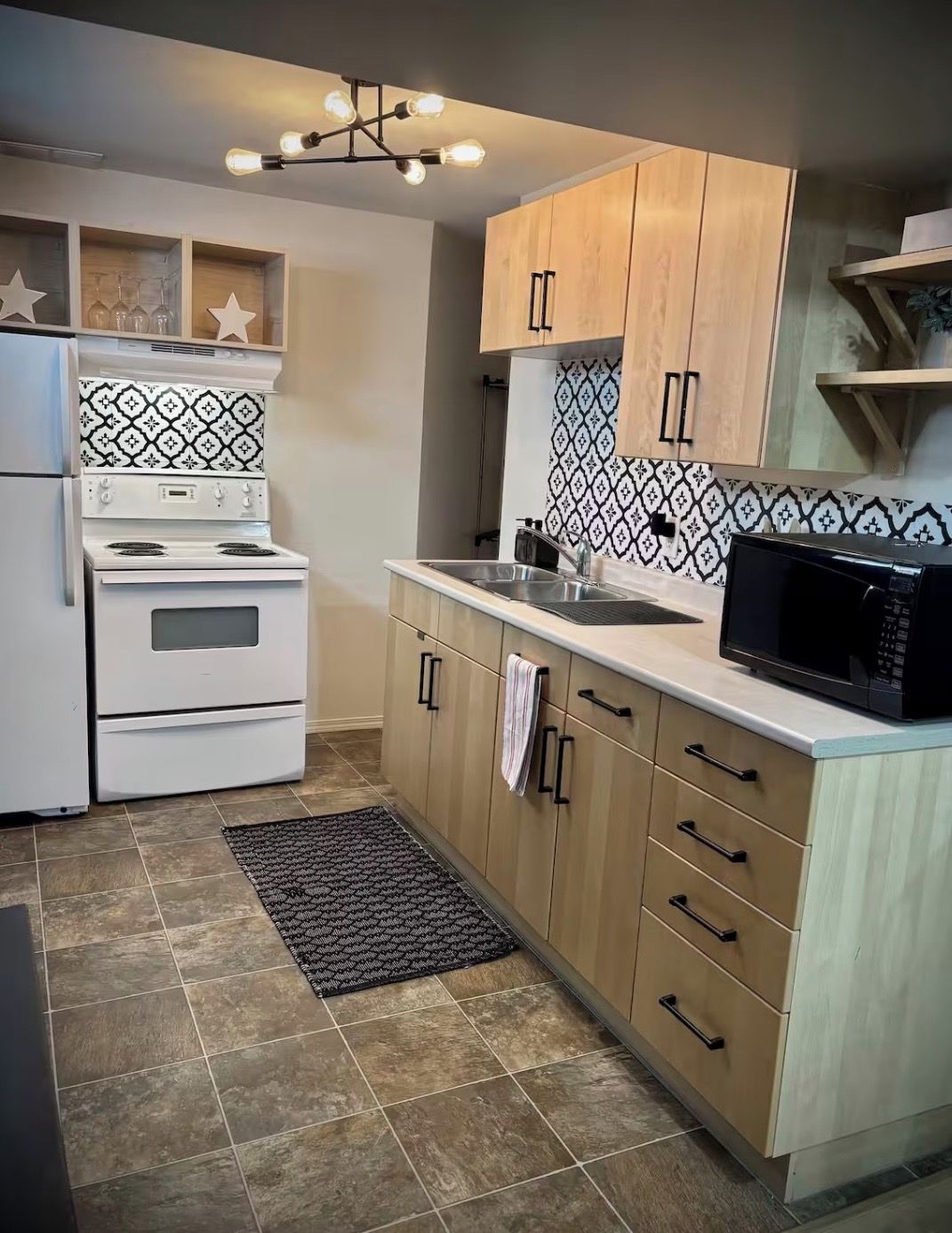 A kitchen with white appliances, a patterned backsplash, and wooden cabinets.