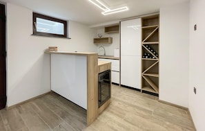 Una cucina compatta con elettrodomestici integrati, una cantina e un piccolo forno.