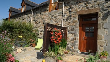 Un bâtiment en pierre avec une porte en bois et un balcon.