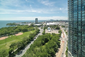 A high-rise building with a view of a park, a baseball field, and a stadium. - Sleek Studio in Fort York Near Lake & Liberty (Toronto)