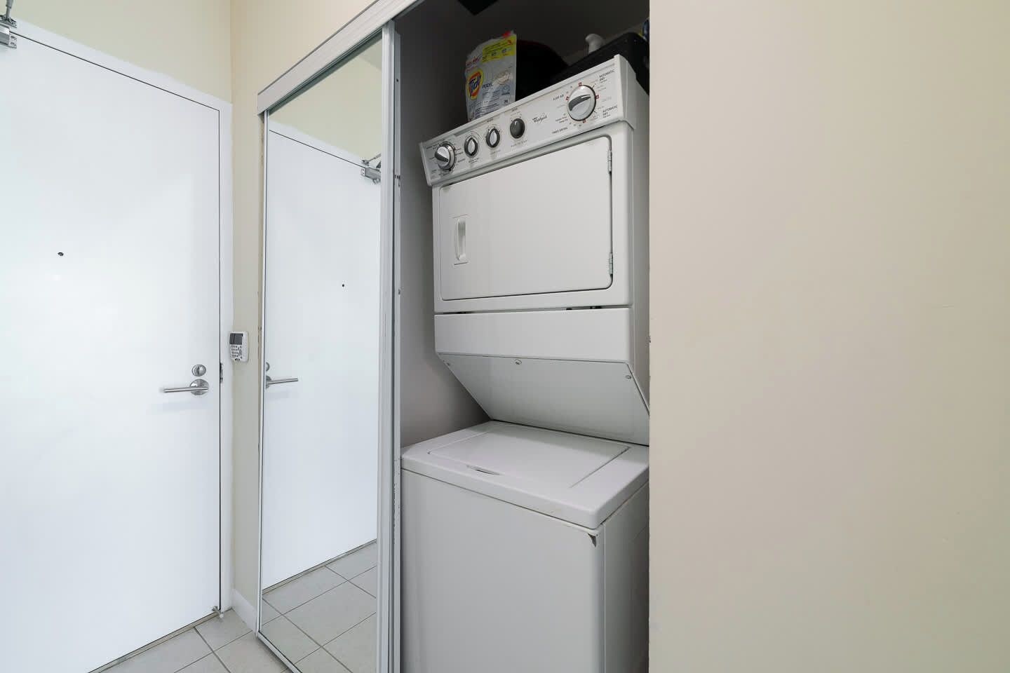 Une buanderie avec un lave-linge blanc, un sèche-linge et une porte.