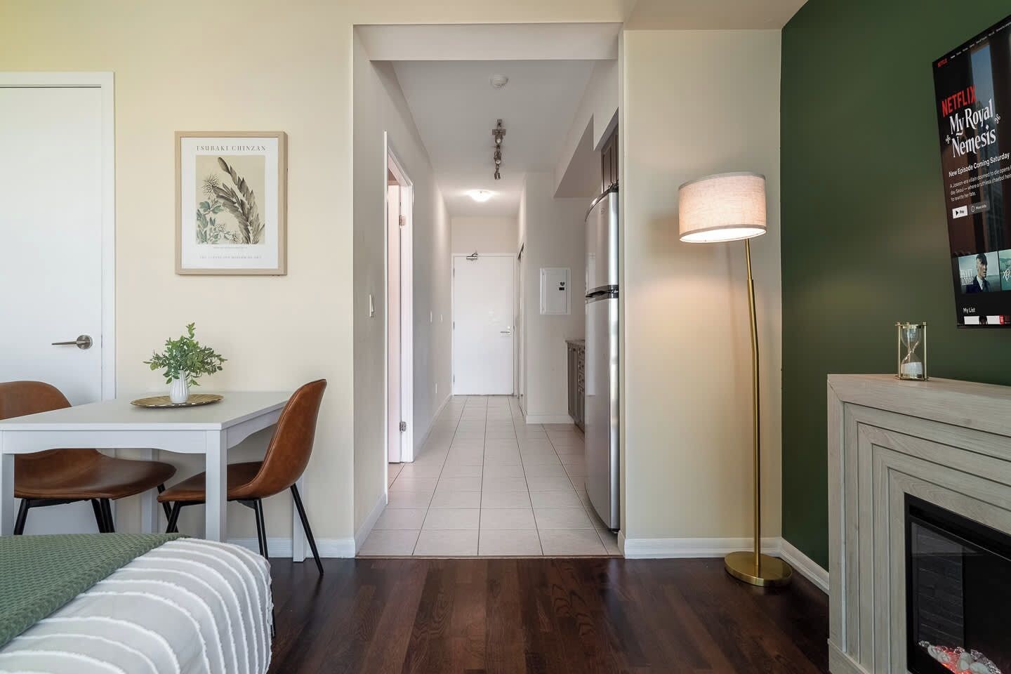 Een moderne woonkamer met een eethoek, een open haard en een gang die naar een keuken leidt.