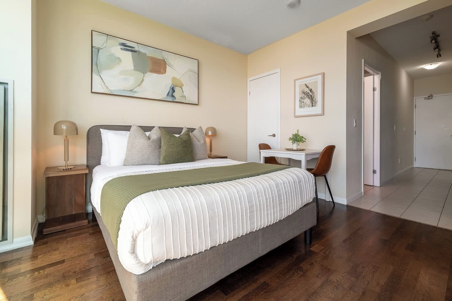 Une chambre à coucher avec un lit, des tables de chevet, un bureau et des chaises.