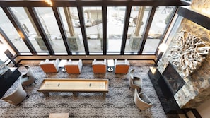 Ein geräumiges Zimmer mit großem Fenster, einem Holztisch und mehreren gepolsterten Stühlen.
