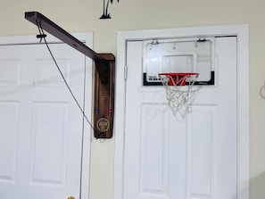 En basketkorg som är fastsatt på en dörr, med en träplatta under.