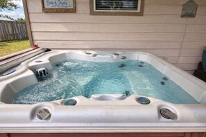 A hot tub with multiple jets, a wooden deck, and a house with a porch. - Coastal Hangout | Hot Tub | GameRm | Mins2Bch (Panama City)