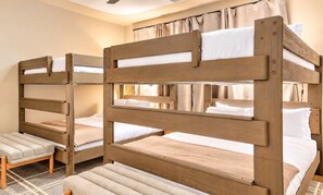 A room with bunk beds, a small stool, and a patterned rug. - Nash Lux - Pool/Hot tub - 11 beds - Game Room! (Nashville)
