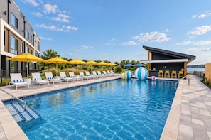A swimming pool with lounge chairs and umbrellas, a bar area, and a view of the water. - Nash Lux - Pool/Hot tub - 11 beds - Game Room! (Nashville)