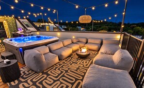A rooftop terrace with a hot tub, outdoor seating, string lights, and a fire pit. - Nash Lux - Pool/Hot tub - 11 beds - Game Room! (Nashville)