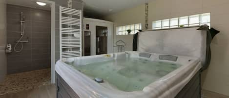 Un baño moderno con bañera de hidromasaje, zona de ducha y cabina de ducha.