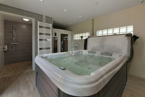 A modern bathroom with a hot tub, a shower area, and a walk-in shower. - Le Lilas - Petfriendly - Jacuzzi, sauna (La Ferrière-aux-Étangs)