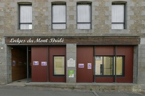 A building with a sign reading 'Lodges du Mont Brule'. - Le Lilas - Petfriendly - Jacuzzi, sauna (La Ferrière-aux-Étangs)