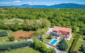 A residential property with a swimming pool, surrounded by lush greenery and mountains in the background. - Casa St. Domenica your peaceful holiday retreat (Vrećari)