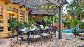 An outdoor patio with a table and chairs, a grill, and a pool. - Palm Manor by Avantstay Historic Home + Private Pool Pergola Dining + Lawn Mins to Downtown (Phoenix)