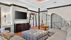 A spacious living room with a flat-screen TV, a fireplace, a staircase, and a cozy seating area. - Palm Manor by Avantstay Historic Home + Private Pool Pergola Dining + Lawn Mins to Downtown (Phoenix)