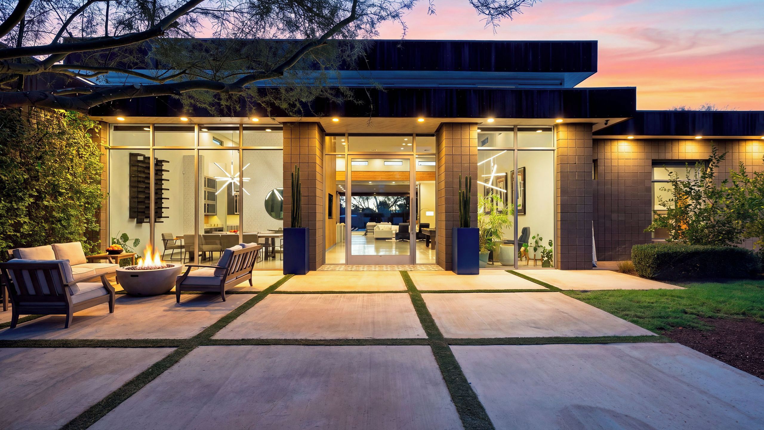 A modern house with a patio area featuring outdoor furniture and a fire pit.