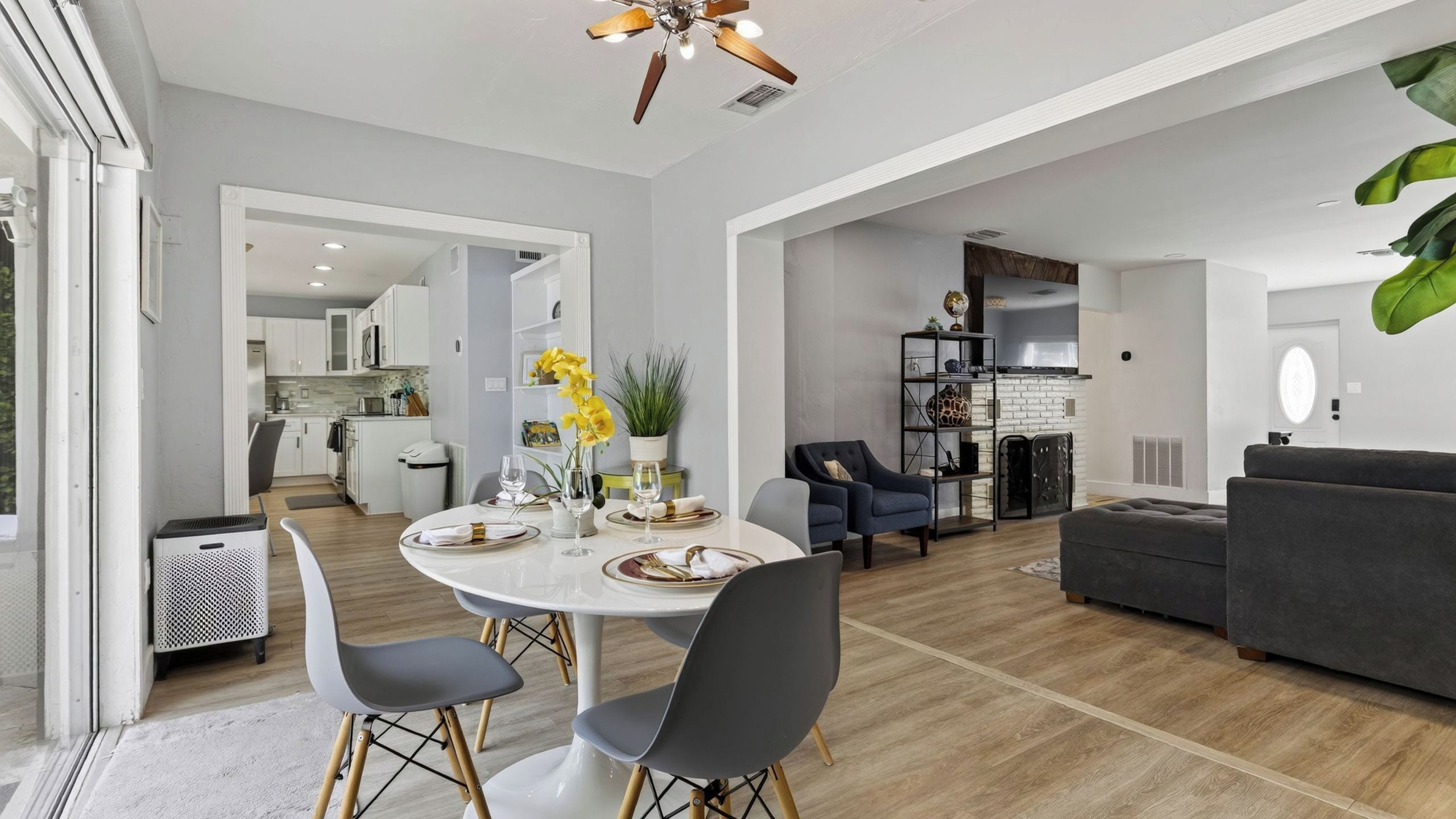 Uma sala de estar moderna com área de jantar, cozinha e espaço de estar com sofá e cadeiras.